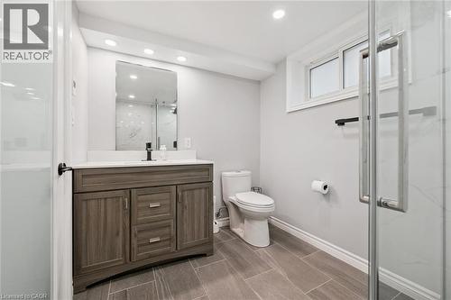Wood-finish vanity with a white countertop and rectangular sink - 49 East Street, Cambridge, ON - Indoor Photo Showing Bathroom