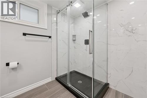 Glass-enclosed shower with white tiled walls, black shower pan, and matte black fixtures - 49 East Street, Cambridge, ON - Indoor Photo Showing Bathroom