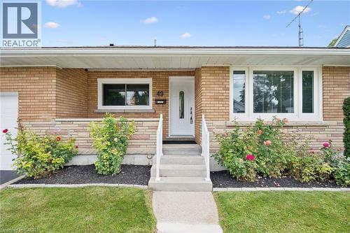 Brick exterior with a stone accent band, white framed windows, and a white entry door - 49 East Street, Cambridge, ON - Outdoor
