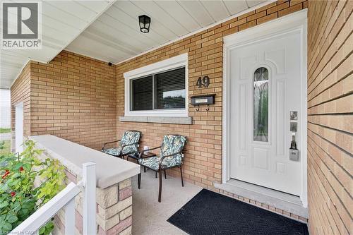 Brick exterior featuring a covered porch, white entry door with decorative glass, and contrasting white trim - 49 East Street, Cambridge, ON - Outdoor With Deck Patio Veranda With Exterior