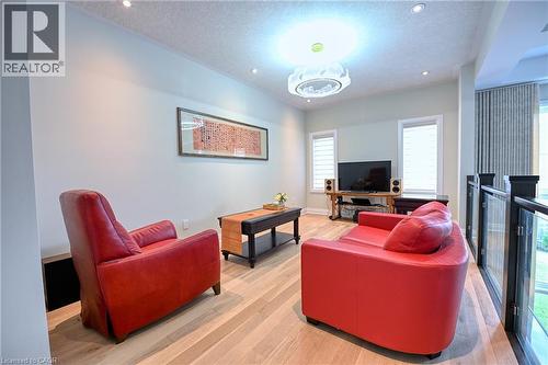 Hardwood-style flooring throughout, recessed lighting, and a modern ceiling fixture - 923 Eaglecrest Court, Kitchener, ON - Indoor Photo Showing Living Room