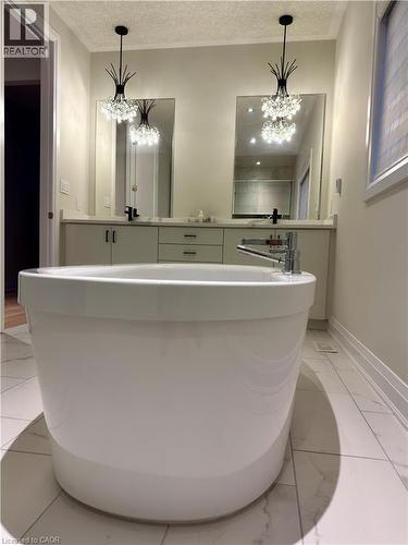 Freestanding soaking tub with chrome fixtures - 923 Eaglecrest Court, Kitchener, ON - Indoor Photo Showing Bathroom