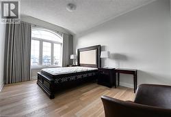 Arched window with extensive glazing, light wood-finish flooring, and neutral wall tones - 
