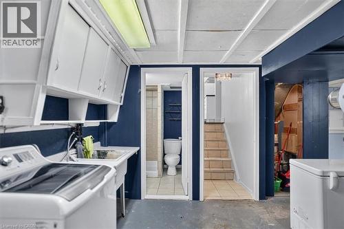 Laundry area with white cabinetry, a utility sink, and a built-in light fixture - 27 Gretna Court, Hamilton, ON - Indoor Photo Showing Laundry Room