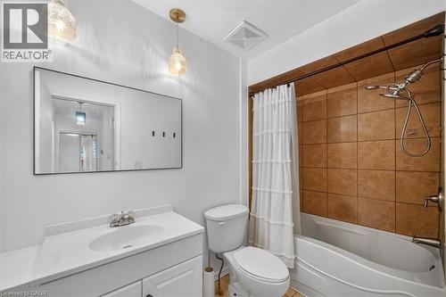 Bathroom featuring a vanity with an integrated sink, a rectangular mirror, a shower-tub combination, and tiled shower surround - 27 Gretna Court, Hamilton, ON - Indoor Photo Showing Bathroom
