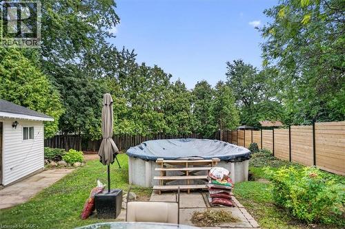 Above-ground pool with wood steps, wood privacy fencing, and mature perimeter trees - 27 Gretna Court, Hamilton, ON - Outdoor