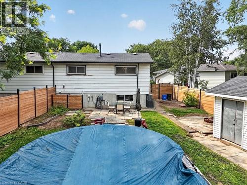 Backyard with a swimming pool, stone patio, wooden fencing, and a separate storage shed - 27 Gretna Court, Hamilton, ON - Outdoor