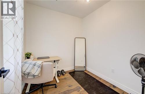Hardwood-finish flooring, white painted walls, and a modern light fixture - 34 St Clair Avenue, Kitchener, ON - Indoor Photo Showing Other Room