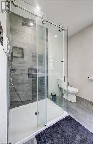 Walk-in shower with clear glass barn-door style enclosure and rainfall showerhead - 34 St Clair Avenue, Kitchener, ON - Indoor Photo Showing Bathroom
