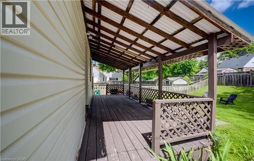Covered outdoor deck with lattice railing and a corrugated roof - 34 St Clair Avenue, Kitchener, ON - Outdoor With Deck Patio Veranda