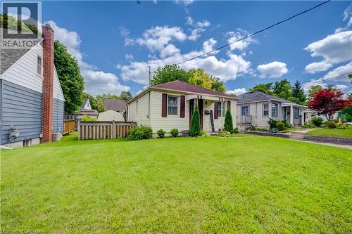 Expansive lawn with mature trees, a covered front porch, and a paved walkway - 34 St Clair Avenue, Kitchener, ON - Outdoor