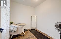 Hardwood-finish flooring, white painted walls, and a modern light fixture - 