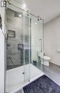 Walk-in shower with clear glass barn-door style enclosure and rainfall showerhead - 