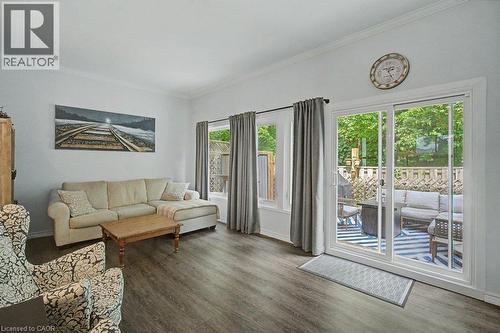 Wood-finish flooring throughout, crown molding detail, sliding glass door to outdoor space, and window with garden lattice - 2050 Upper Middle Road Unit# 164, Burlington, ON - Indoor Photo Showing Living Room
