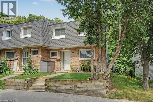 Brick exterior with dormer windows, a gray shingle roof, and a wood-tie retaining wall with steps - 2050 Upper Middle Road Unit# 164, Burlington, ON - Outdoor