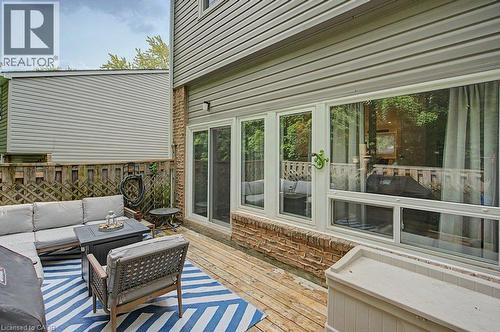 Exterior decking with a wooden privacy fence, brick foundation, and light-colored siding - 2050 Upper Middle Road Unit# 164, Burlington, ON - Outdoor With Deck Patio Veranda With Exterior
