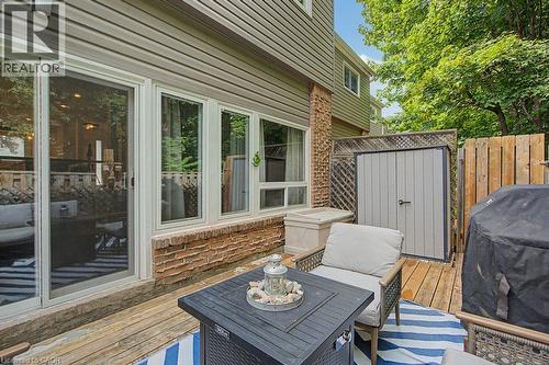 Expansive wood-finish deck with a sliding glass door and multiple windows - 2050 Upper Middle Road Unit# 164, Burlington, ON - Outdoor With Deck Patio Veranda With Exterior