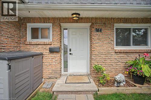 Brick exterior with a white entry door, recessed porch lighting, and a mailbox - 2050 Upper Middle Road Unit# 164, Burlington, ON - Outdoor