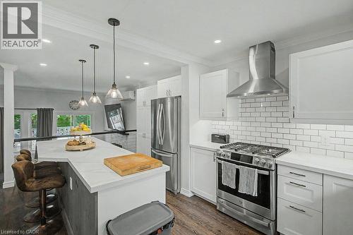 White cabinetry with brushed nickel hardware, stainless steel appliances, subway tile backsplash, white countertops, and recessed lighting - 2050 Upper Middle Road Unit# 164, Burlington, ON - Indoor Photo Showing Kitchen With Upgraded Kitchen