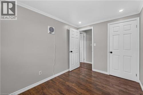 Wood-finish flooring, white crown molding, recessed lighting, and white paneled doors - 66 Summercrest Drive Unit# 3, Hamilton, ON - Indoor Photo Showing Other Room