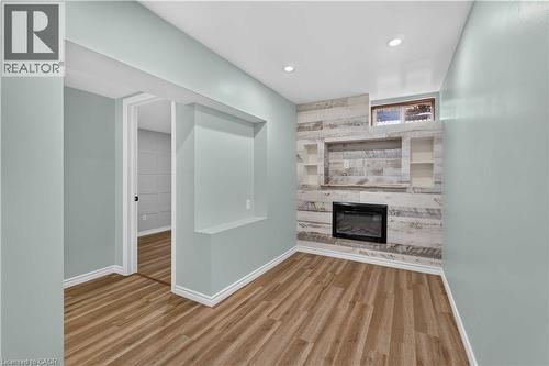 Wood-finish flooring, recessed lighting, and a built-in electric fireplace with stone-look surround - 66 Summercrest Drive Unit# 3, Hamilton, ON - Indoor With Fireplace