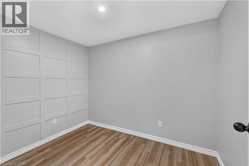 Wood-finish flooring with crisp white trim - 66 Summercrest Drive Unit# 3, Hamilton, ON - Indoor Photo Showing Other Room