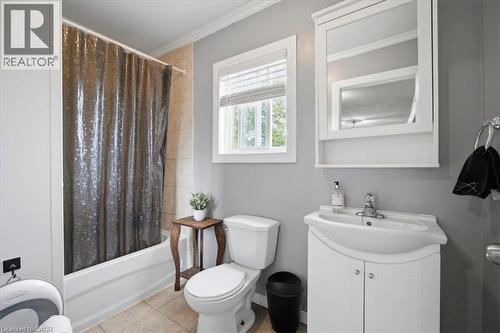 White vanity with integrated sink, wall-mounted mirrored medicine cabinet, and a window with blinds - 22 Delena Avenue N, Hamilton, ON - Indoor Photo Showing Living Room