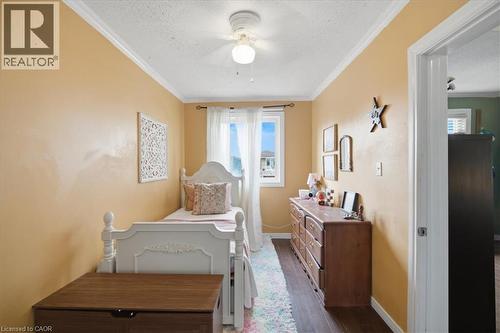 Recessed window with sheer white curtains, dark wood-finish flooring, and white crown molding - 22 Delena Avenue N, Hamilton, ON - Indoor Photo Showing Other Room
