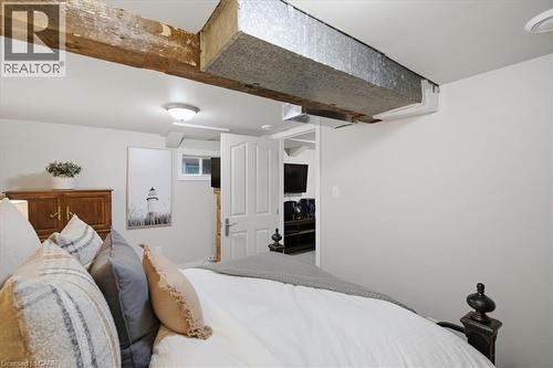 Exposed wood beam and galvanized ductwork ceiling elements, white paneled door, and recessed window - 22 Delena Avenue N, Hamilton, ON - Indoor Photo Showing Bedroom