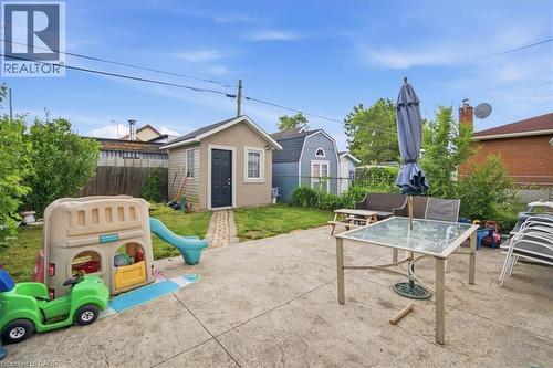 Shed structure, concrete patio, grass area, mature perimeter shrubs, picket fence - 22 Delena Avenue N, Hamilton, ON - Outdoor