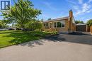 Brick exterior with a peaked roof, wood deck, attached garage, and paved driveway - 185 Burlington Street, London, ON  - Outdoor 