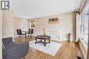 Hardwood flooring, white brick fireplace, built-in shelving, large windows with natural light, and a dedicated dining space - 185 Burlington Street, London, ON  - Indoor Photo Showing Living Room 