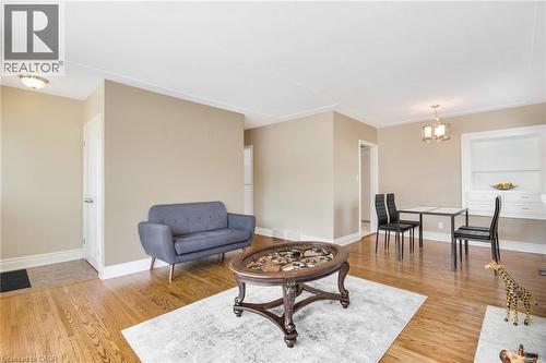 Hardwood flooring, crown molding, flush-mount ceiling light, and a built-in cabinet with shelving - 185 Burlington Street, London, ON - Indoor Photo Showing Living Room