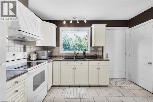 Kitchen featuring white cabinetry, gray stone-finish countertops, and a tile backsplash - 185 Burlington Street, London, ON - Indoor Photo Showing Kitchen With Double Sink