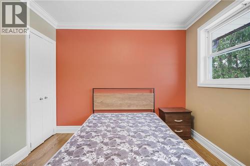 Hardwood-style flooring, white bi-fold closet doors, white window trim, and crown molding - 185 Burlington Street, London, ON - Indoor Photo Showing Bedroom