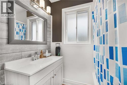 Vanity with integrated sink, chrome faucet, and storage cabinetry - 185 Burlington Street, London, ON - Indoor Photo Showing Bathroom