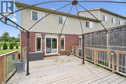 Ground-level wood deck with a metal gazebo frame, brick exterior wall, and sliding glass doors - 308 Parkvale Drive, Kitchener, ON - Outdoor With Deck Patio Veranda With Exterior