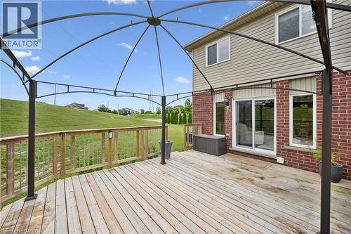 Expansive wooden deck with wooden railings, red brick exterior, siding upper level, and a sliding glass door - 308 Parkvale Drive, Kitchener, ON - Outdoor With Deck Patio Veranda With Exterior