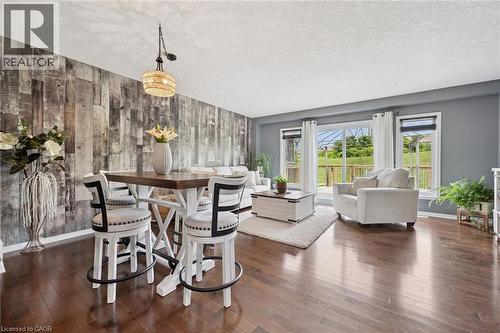 Distressed wood-finish accent wall, wood-finish flooring, recessed lighting, double-pane windows, and a sliding glass door - 308 Parkvale Drive, Kitchener, ON - Indoor Photo Showing Other Room