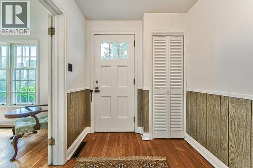Hardwood flooring, paneled walls, white paneled door with decorative glass inserts, and louvered bifold closet doors - 321 Highland Park, Cambridge, ON 