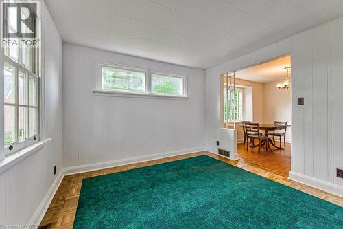 Parquet flooring, vertical paneling, transom windows, and a cased opening with decorative screen - 321 Highland Park, Cambridge, ON 