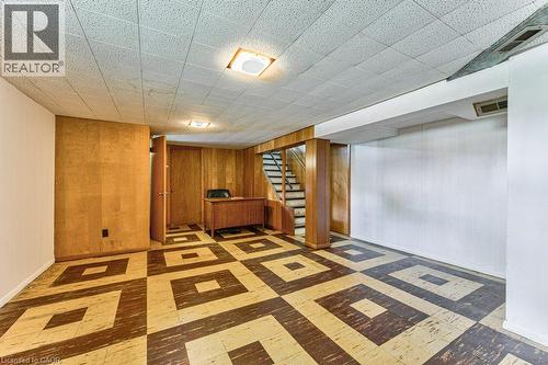 Spacious interior with patterned tile flooring, wood-paneled walls, and a recessed staircase - 321 Highland Park, Cambridge, ON 