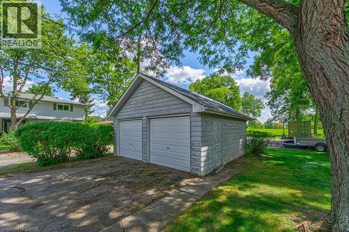 Detached two-car garage with shingle siding, asphalt driveway, and mature landscaping - 321 Highland Park, Cambridge, ON 