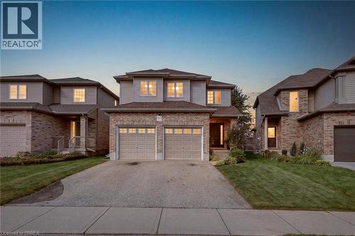 Two-story residence featuring a brick and siding exterior, a double garage, and a concrete driveway - 783 Frontenac Crescent, Woodstock, ON - Outdoor With Facade
