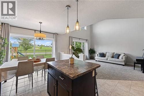 Spacious open-concept layout featuring high vaulted ceilings, large sliding glass doors, contemporary pendant lighting, and a kitchen island with storage - 783 Frontenac Crescent, Woodstock, ON - Indoor