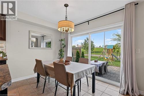 Tiled flooring, overhead light fixture, sliding glass door, paved patio, and fenced backyard - 783 Frontenac Crescent, Woodstock, ON - Indoor Photo Showing Dining Room