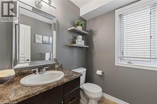 Bathroom with a single vanity, a polished chrome faucet, and a decorative framed mirror - 783 Frontenac Crescent, Woodstock, ON - Indoor Photo Showing Bathroom