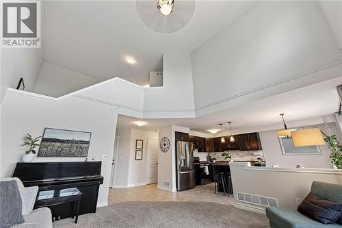 Vaulted ceilings, open concept design, a kitchen with dark wood cabinetry, stainless steel appliances, and a tiled kitchen backsplash - 783 Frontenac Crescent, Woodstock, ON - Indoor