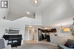 Vaulted ceilings, open concept design, a kitchen with dark wood cabinetry, stainless steel appliances, and a tiled kitchen backsplash - 