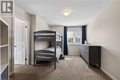 Window with blinds, wall-to-wall carpeting, overhead lighting fixture, and white interior door - 783 Frontenac Crescent, Woodstock, ON - Indoor Photo Showing Bedroom